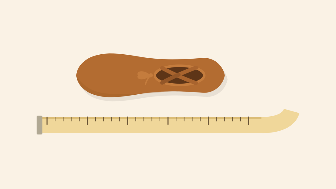 A canvas ballet slipper seen from above beside a tape measure, showing the opening, drawstring and criss-cross elastics.
